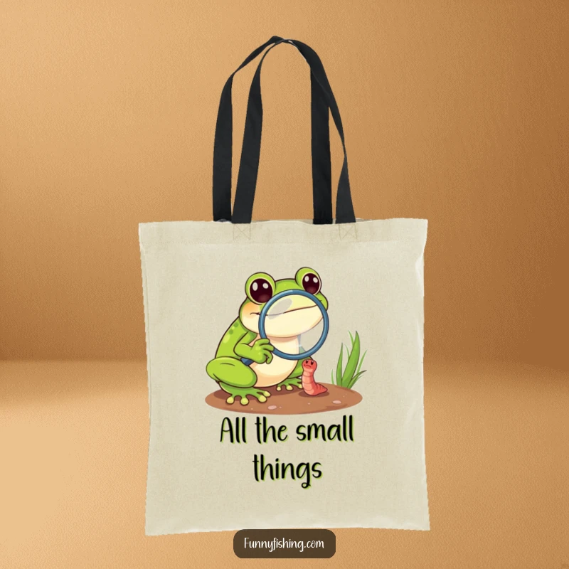Funny frog tote bag featuring a cheerful frog using a magnifying glass to examine a tiny, struggling worm, great for daily use.